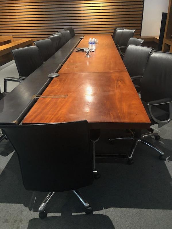 The before photo of a custom conference table that was built into a room and could not be removed in a single piece. This room was a full demo of built-in furniture so that it be remodeled.